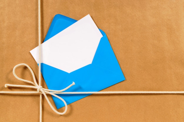 Foto gratuita pacchetto con busta blu e scheda messaggio vuoto