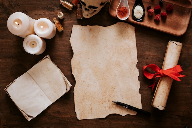 Parchment and ink pen near candles and ingredients