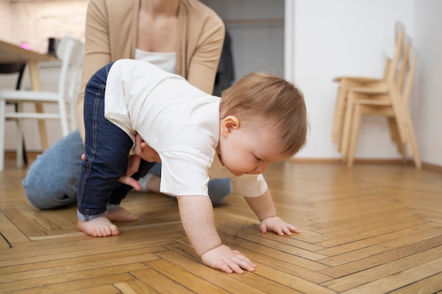 Parent helping baby crawl high angle