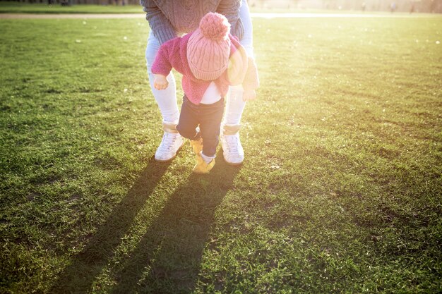 Free photo parent helping kid walk in nature