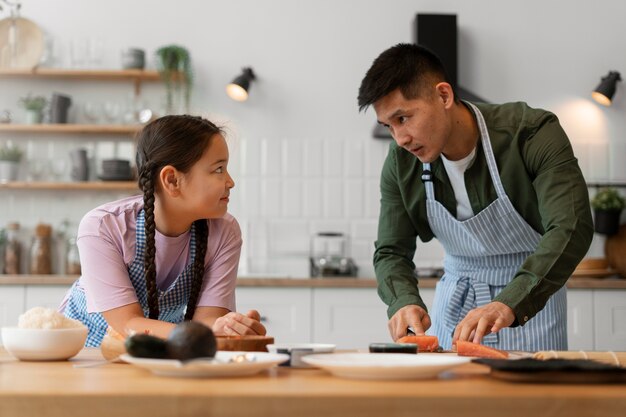 Foto gratuita genitore che insegna al figlio a fare il sushi