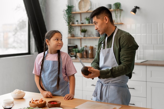 Free photo parent teaching kid how to make sushi