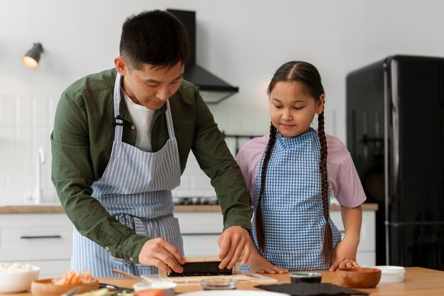 子どもに寿司を作る方法を教える親