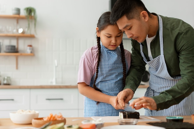 Parent teaching kid how to make sushi