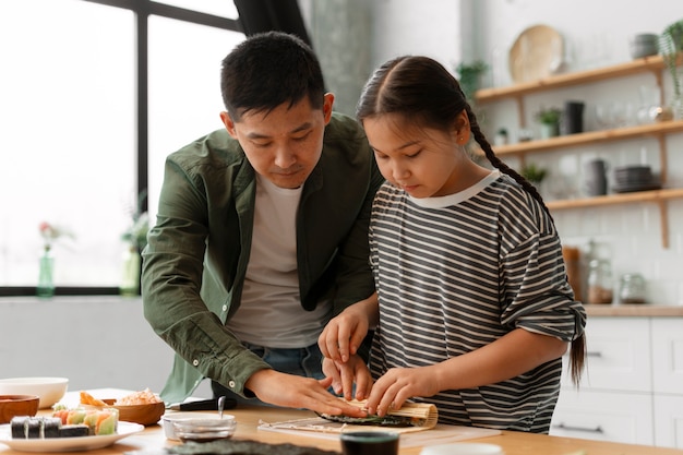 子どもに寿司を作る方法を教える親