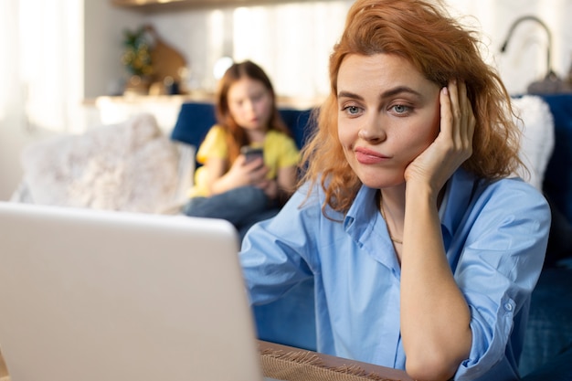 Free photo parent trying to work from home surrounded by kids