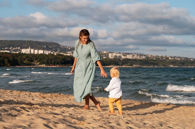 Родитель с ребенком на пляже при заходе солнца