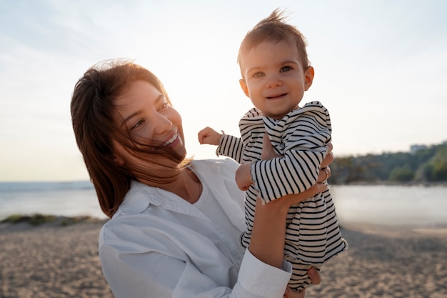 Parent with a baby on the beach at sunset