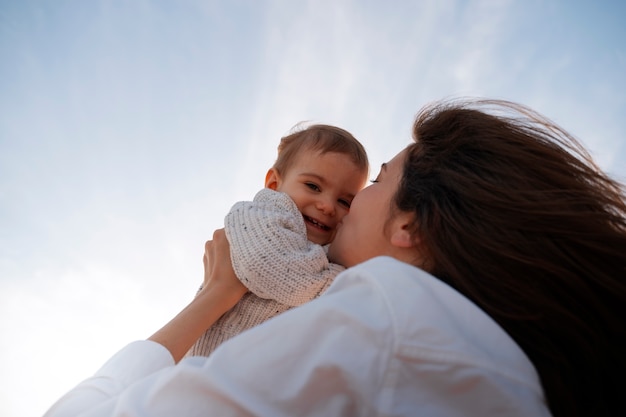 Free photo parent with a baby on the beach at sunset