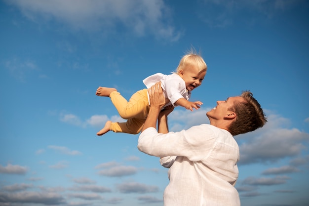 Free photo parent with a baby on the beach at sunset