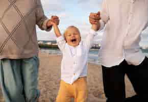 Foto gratuita genitore con un bambino sulla spiaggia al tramonto