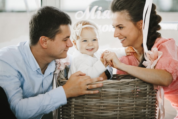 Parents are playing with their little daughter