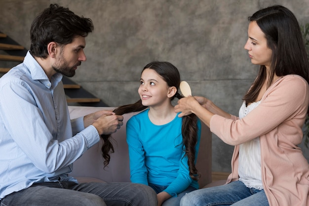 Parents brushing daughter hair