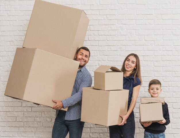 Родители и ребенок, держащий картонные коробки