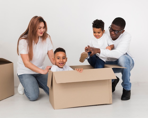 Parents and children playing with a box