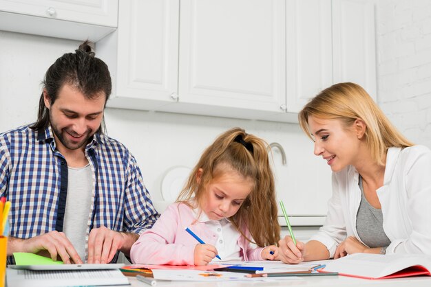 parents and daughter coloring together