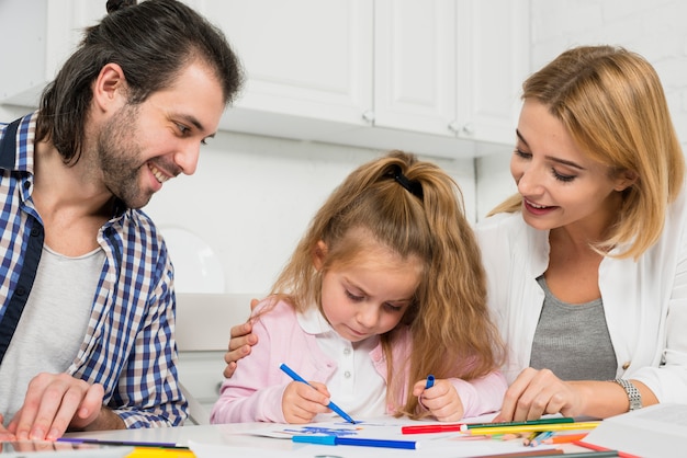 parents and daughter coloring together