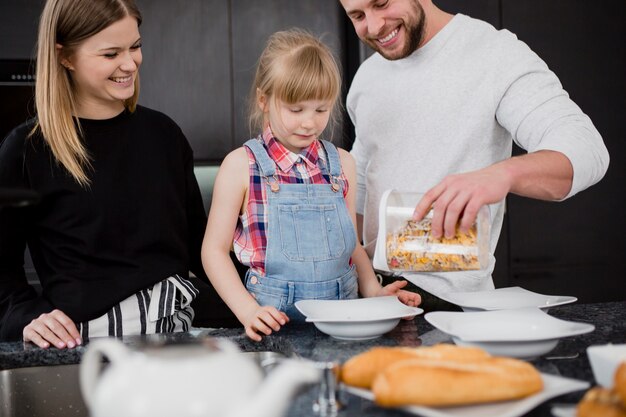 Parents and daughter cooking breakfast