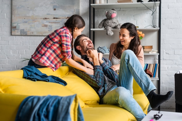 Parents and daughter fooling around in living room