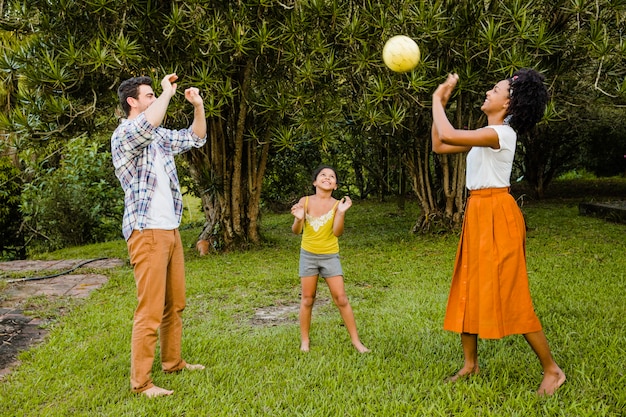 Родители и дочь играют в мяч