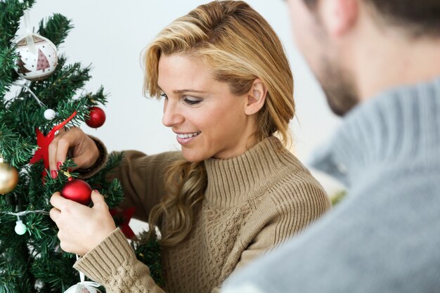 Foto gratuita i genitori che decorano l'albero di natale