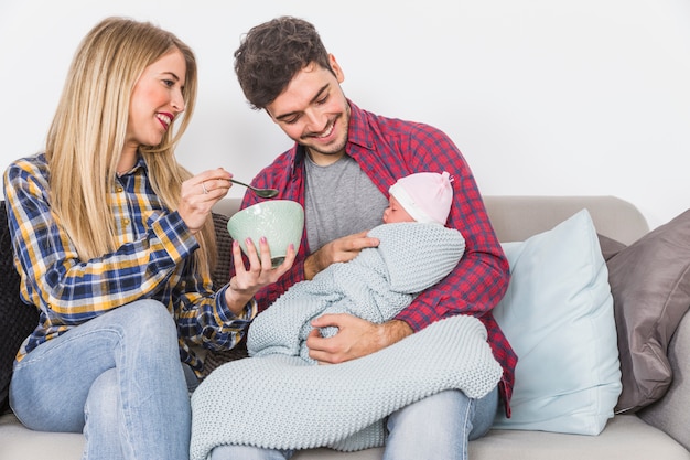 Parents feeding baby with spoon 