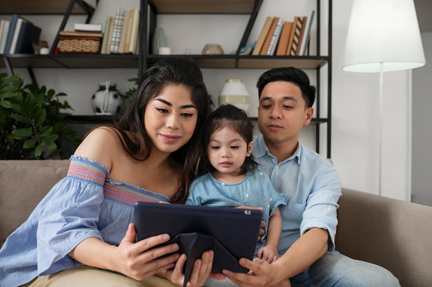 Parents and girl with tablet medium shot