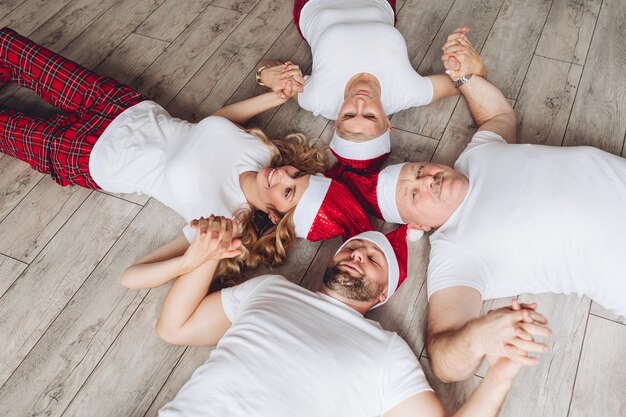 Parents and grandparents spend christmas time and relaxes on the floor together