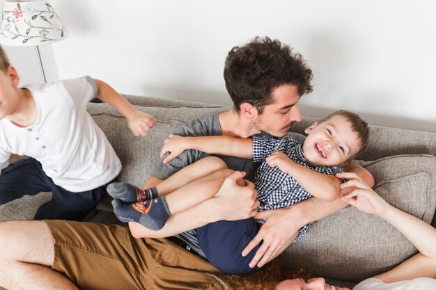 parents having fun with their sons on sofa