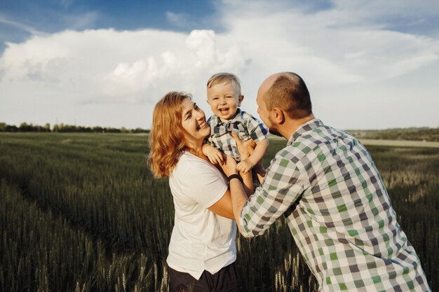 Parents hold their little son and they have fun