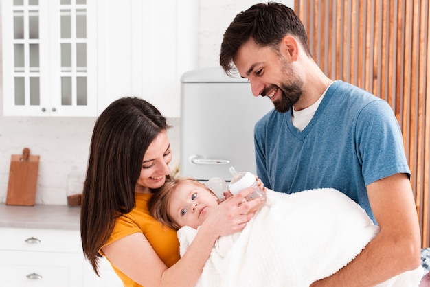 Free photo parents holding baby in blanket