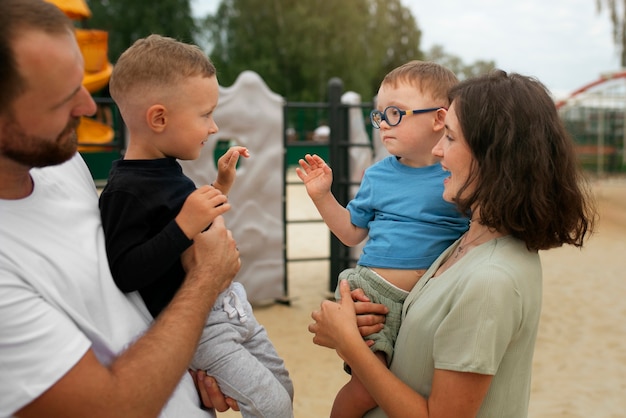 Foto gratuita genitori che tengono la vista laterale dei bambini