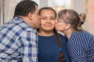 Free photo parents kissing daughter