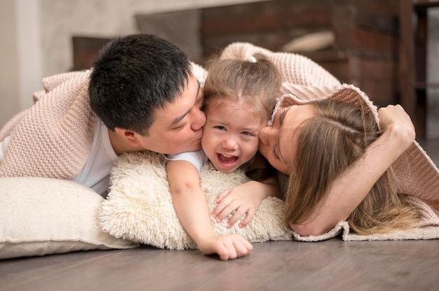 Free photo parents kissing girl