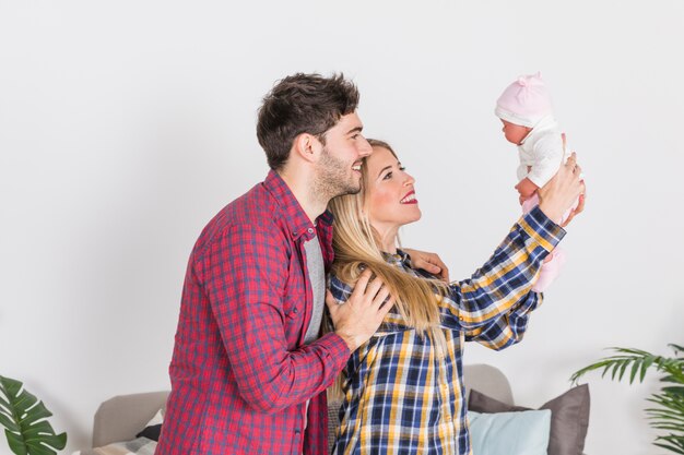 Free photo parents looking at baby in hands