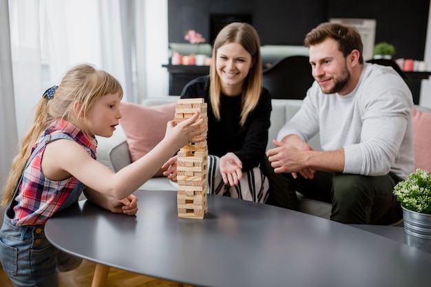 Parents looking at daughter removing blocks