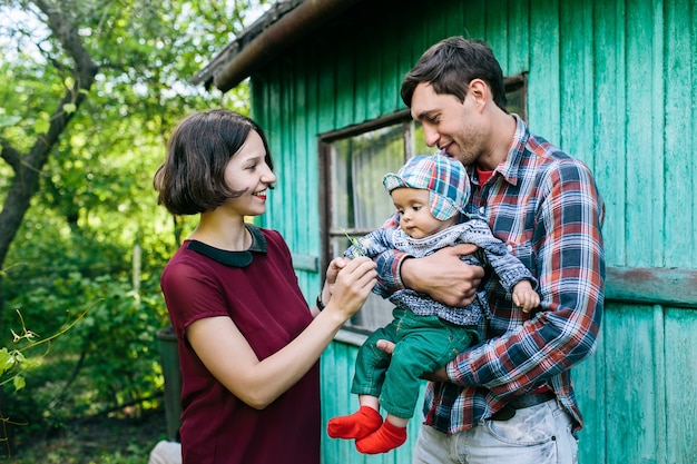 Parents playing with toddler outside of house