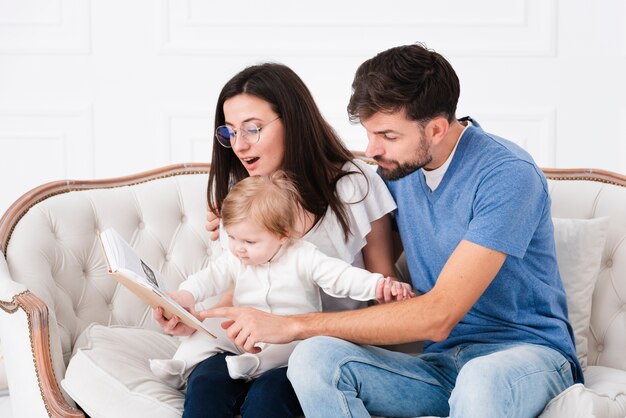 Parents reading while holding baby