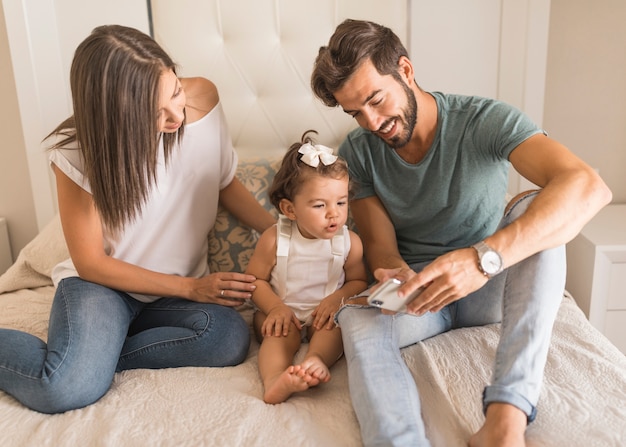 Parents showing smartphone to daughter