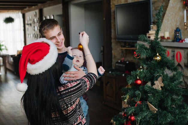 Parents showing their baby a christmas ball