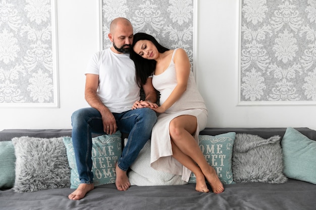 Parents sitting together on sofa