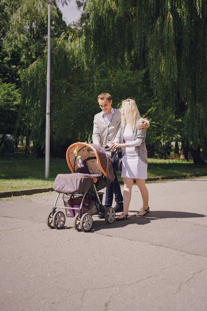 Родители, прогуливающиеся детскую коляску