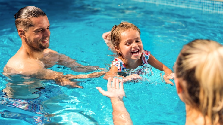 Free Photo parents teaching their daughter swimming in the pool