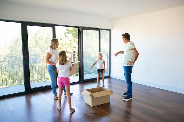 Parents and their children talking during removal in new house