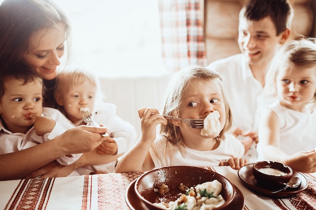 I genitori e i loro quattro figli ascoltano deliziosi vareniki