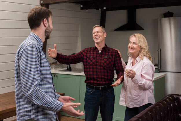 Parents welcoming son in the kitchen