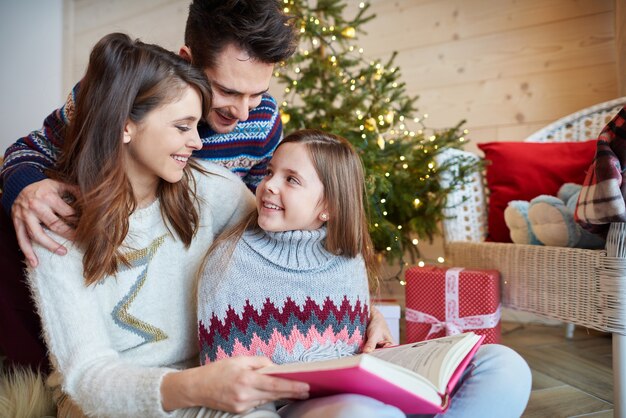 Parents with cute girl reading fairytales