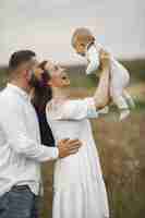 Foto gratuita genitori con figlia. famiglia in un campo. ragazza appena nata. donna in abito bianco.