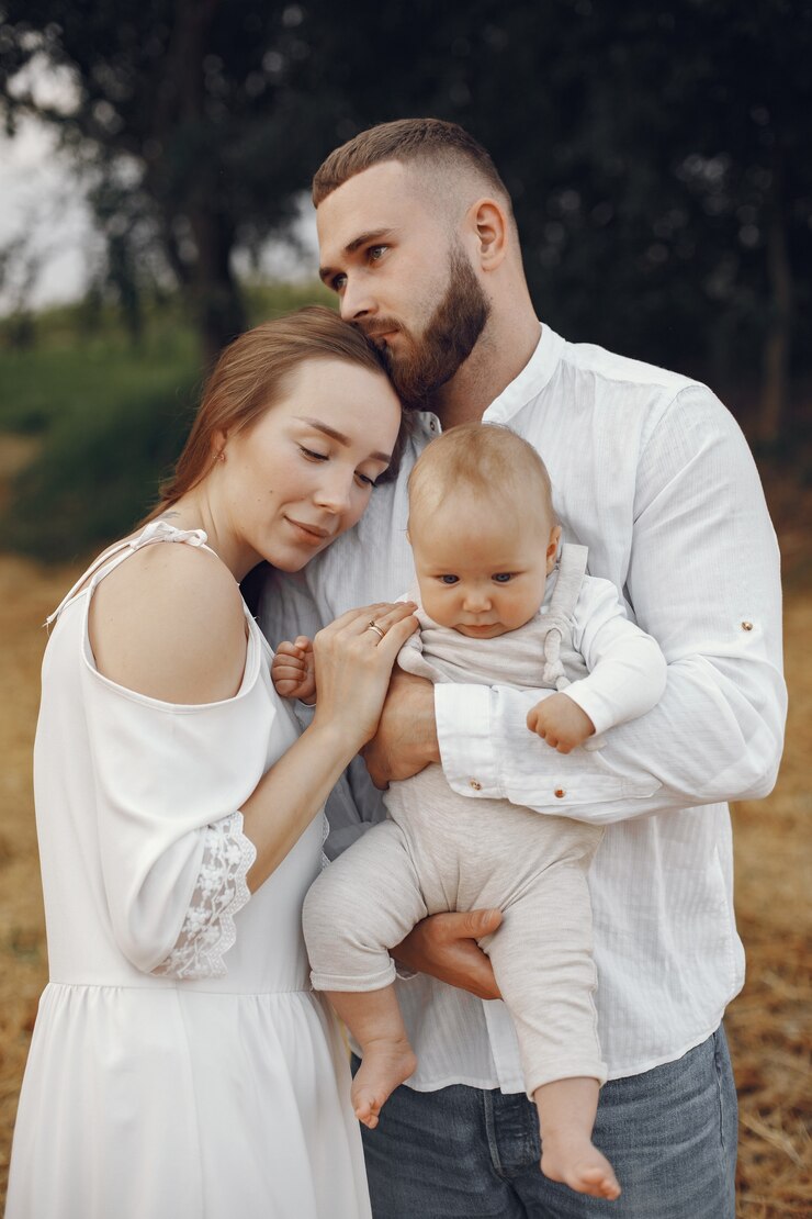 Free Photo parents with daughter. family in a field. newborn girl. woman in a white dress.