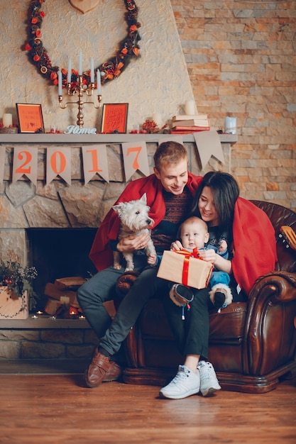 Parents with a dog and a baby and a guitar resting on the couch